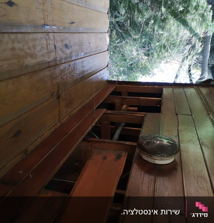 צינורות מתחת לרצפת עץ עם לוח עץ פתוח